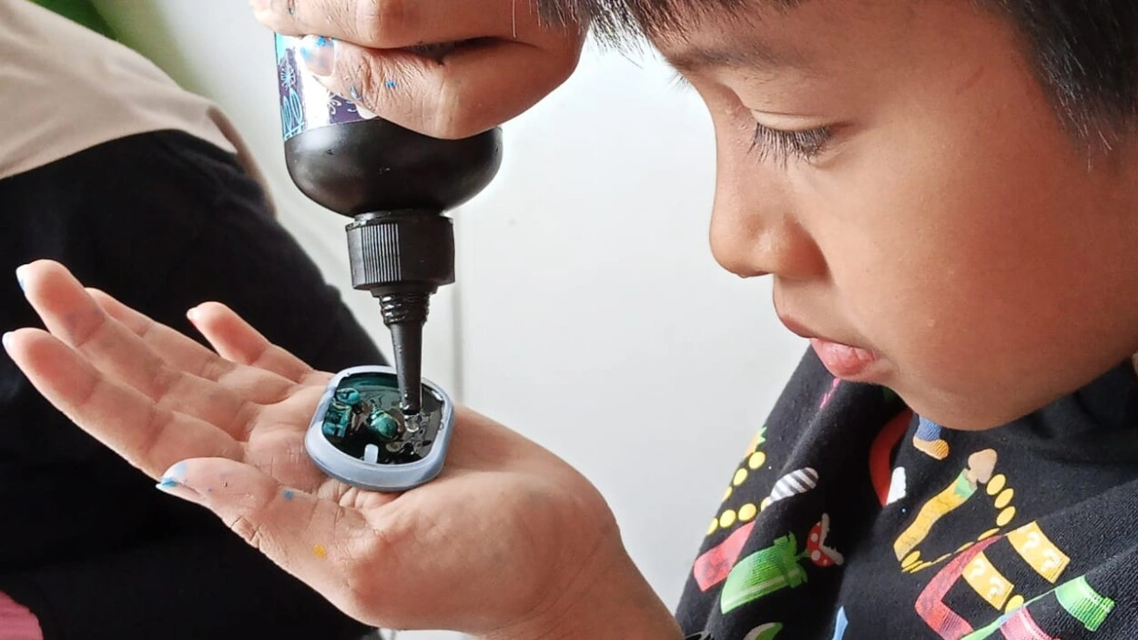 Darryl, salah seorang peserta workshop Craft Therapy semangat menuangkan cairan pewarna. (Foto: TRENDS.co.id)